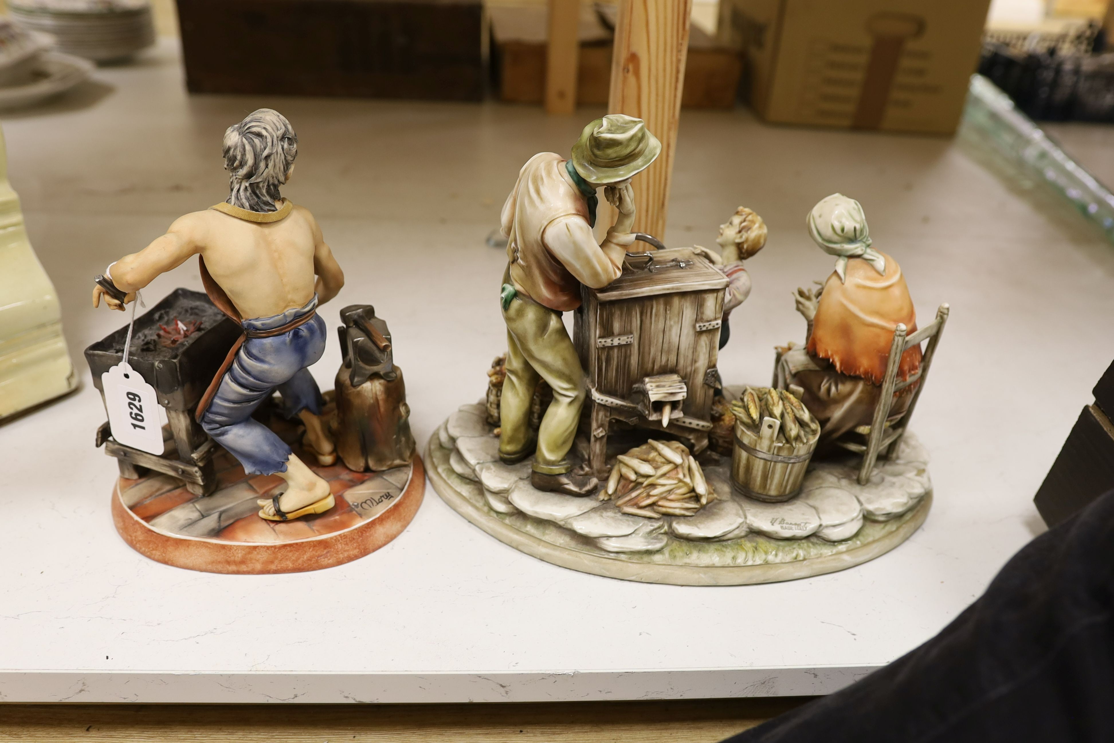 A Capodimonte figure group of a peasant family with organ grinder together with a smaller figure of a blacksmith, Organ grinder figure group 32 cms wide.